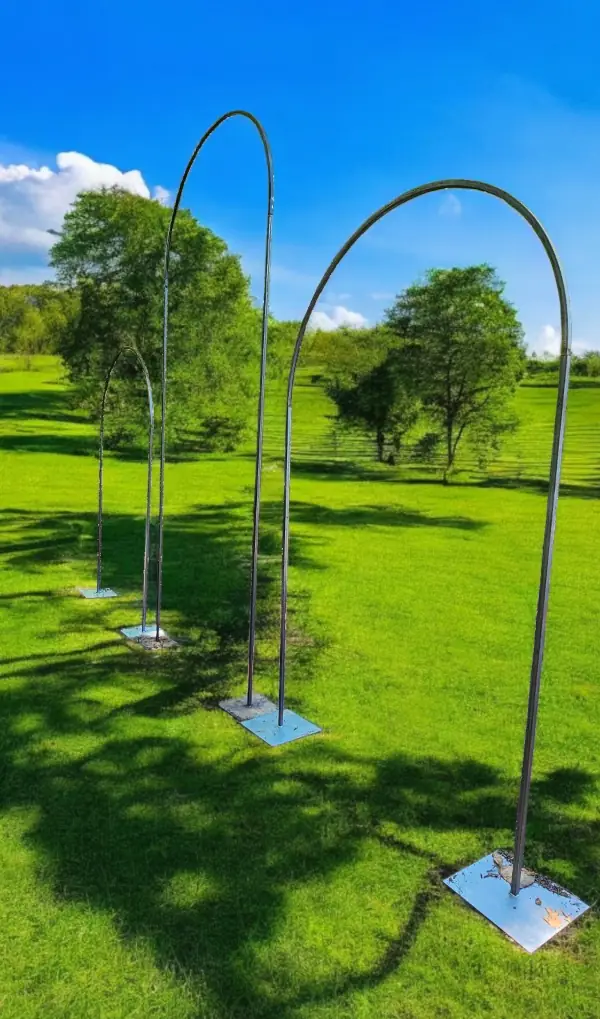 Freestanding metal event arches arranged outdoors in a grassy Atlanta venue, showing customizable structure sizes.